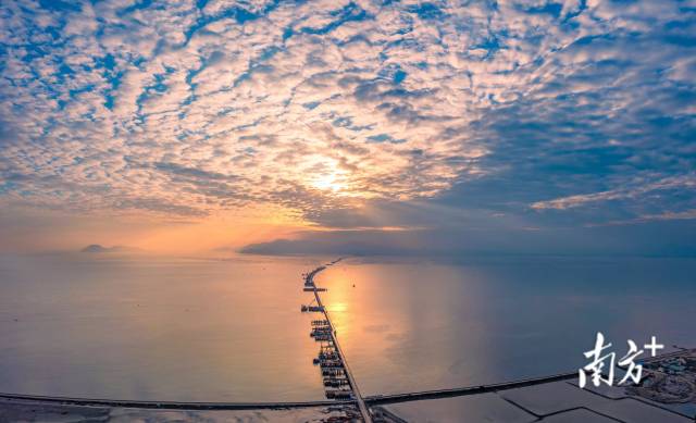 夕阳西下，一条“跨海巨龙”骨架初显。黄茅海跨海通道连接珠海和江门，将于2024年建成通车。  