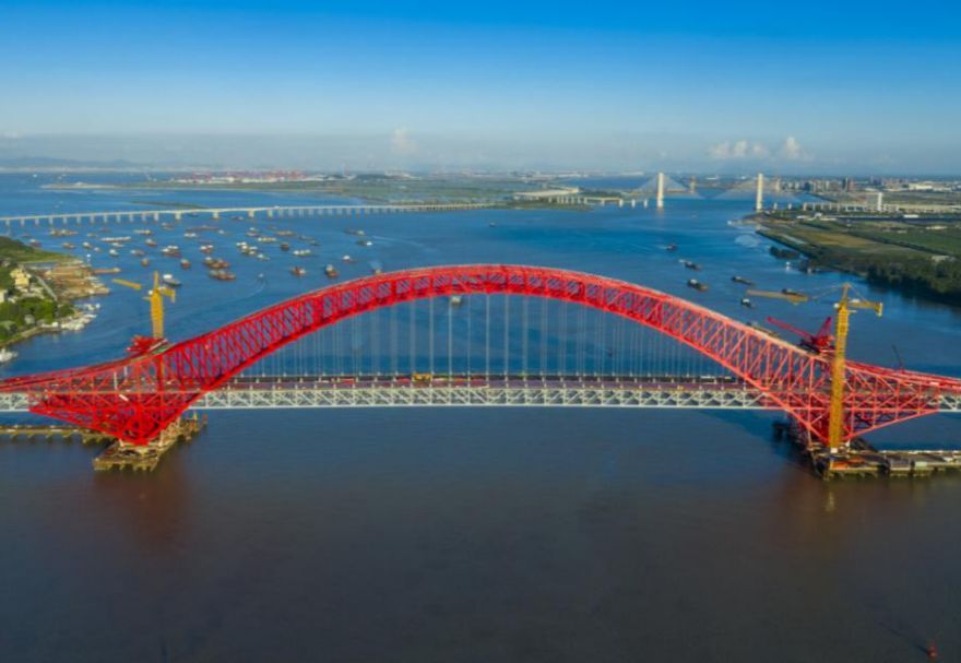 明珠湾大桥位于广州市南沙区龙穴南水道之上，是粤港澳大湾区的重要连接通道。大桥工程全长约10.42公里，主线全长约9.1公里，主桥采用中承式六跨连续钢桁拱桥，全长1016米，为同类型桥梁最大跨度。气势恢宏的明珠湾大桥绵延伸向远方，将南沙多条核心主干道紧紧连在一起，构筑了明珠湾区内部核心交通环，是广州面向粤港澳大湾区建设的交通枢纽工程和地标性建筑。图为南沙明珠湾大桥。