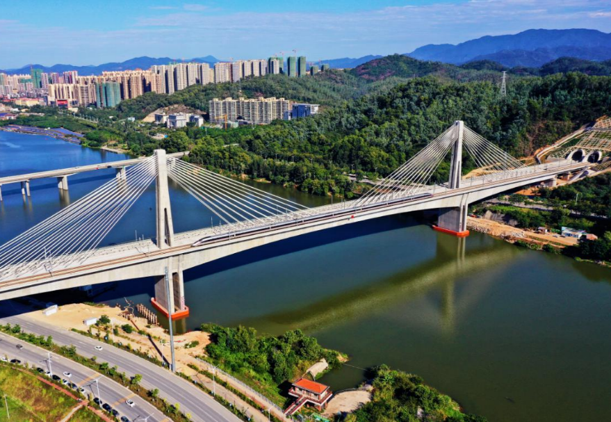 剑潭东江特大桥位于惠州，是赣深高铁和广汕铁路联络线跨越东江的共同的通道，桥梁全长925米，主跨260米，桥面宽度31米，梁面以上塔高56米，是世界最大跨度、最大宽度的四线高速铁路混凝土部分斜拉桥。为了保证列车的高速行车要求，桥上四线均采用了无砟轨道，是目前世界上铺设无砟轨道最大跨度的混凝土桥梁。大桥建成通车后，全面打通了广州——粤东北和江西、深圳——京九线沿途各地区的高铁线路。图为剑潭东江特大桥。