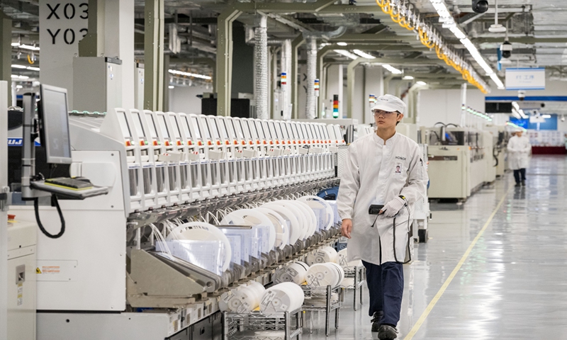 Workers walk along an assembly line at Honor Device Co, a smartphone maker located in an intelligent industrial park in the southern Chinese city of Shenzhen on December 14, 2023. Photo: Chen Tao/GT