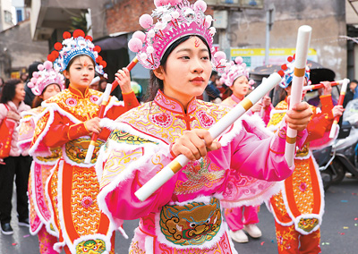  春节期间，英歌舞队员在广东省汕头市潮阳区海门镇街头巡游表演。王文摄（人民视觉）