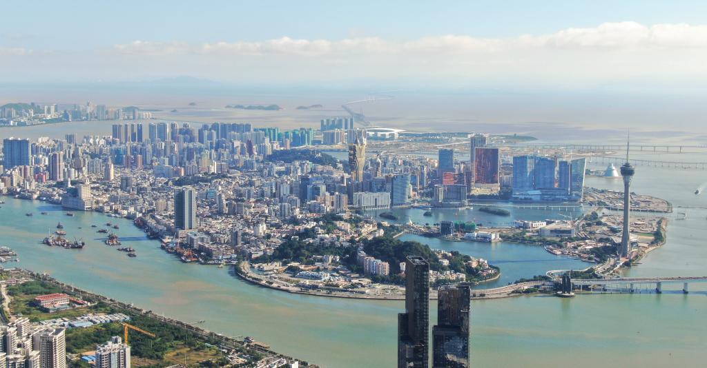 从珠海市区拍摄的澳门及远处的港珠澳大桥（2024年11月26日摄，无人机照片）。新华社记者邓华摄