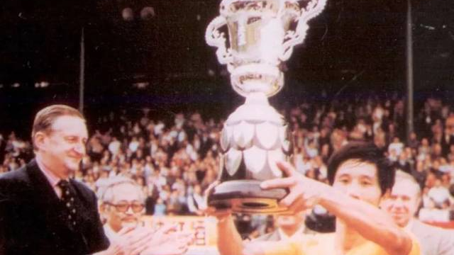 1979年，广东队队长何佳在香港捧起首届省港杯冠军奖杯。图源网络