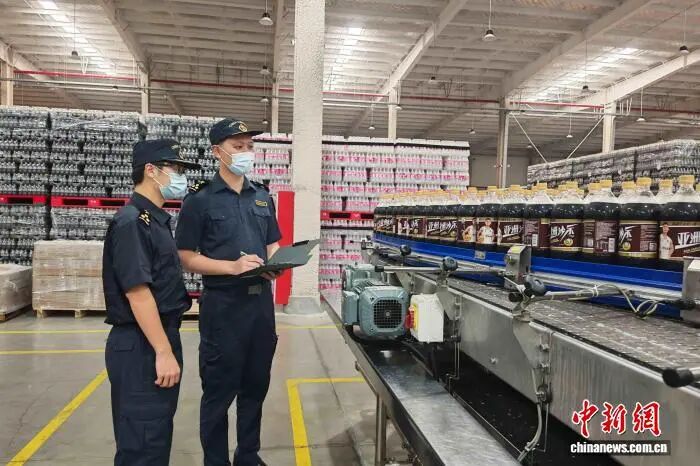 广州海关所属肇庆海关关员对即将出口的饮料进行监管。广州海关供图